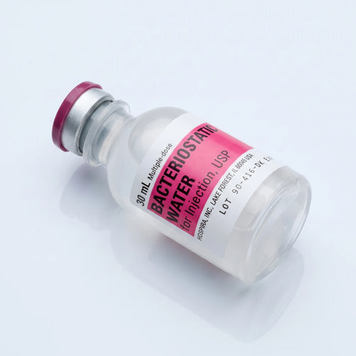 30 ml bacteriostatic water vial lying at a diagonal with the pink Hospira label facing the camera