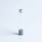 3 ml glass pen cartridge standing upright: silver crimp cap with center septum on top, ribbed rubber plunger seated inside the glass at the base