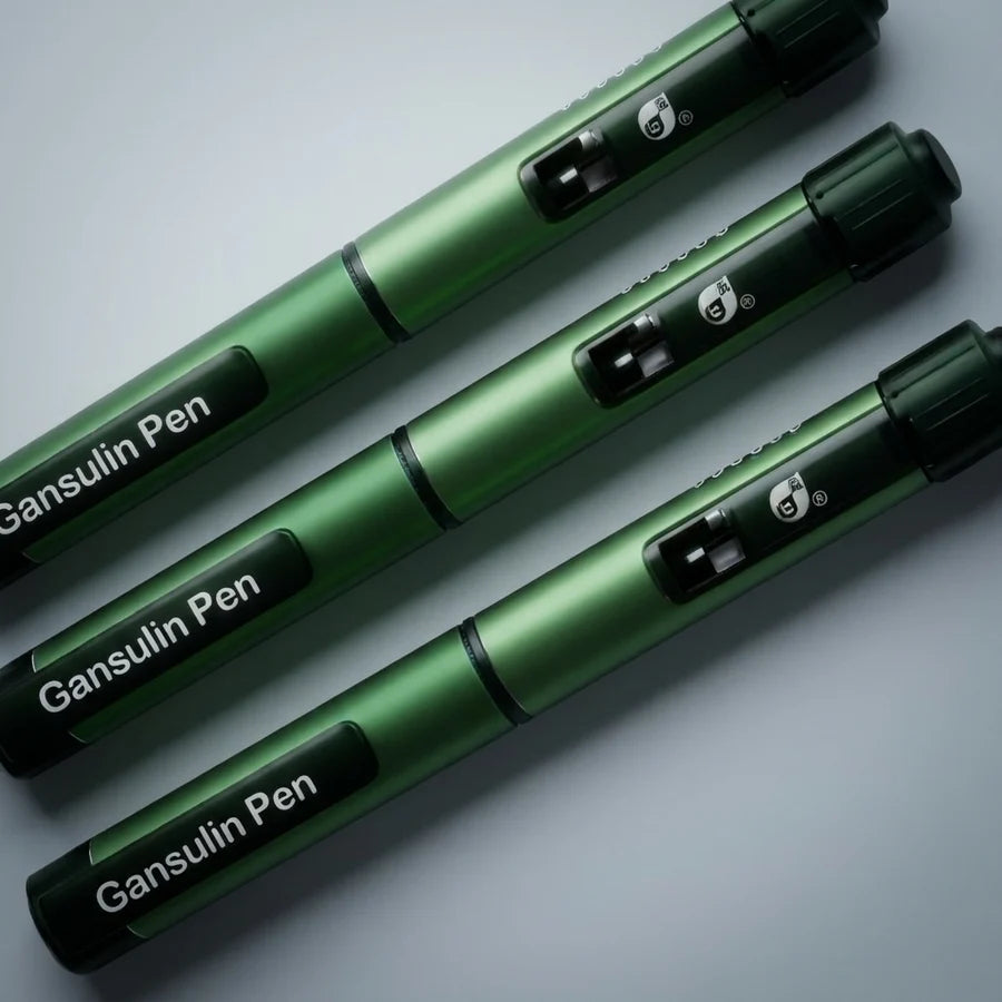Three Gansulin all-metal pens fanned diagonally on a studio backdrop, satin green anodized bodies with gloss black fittings
