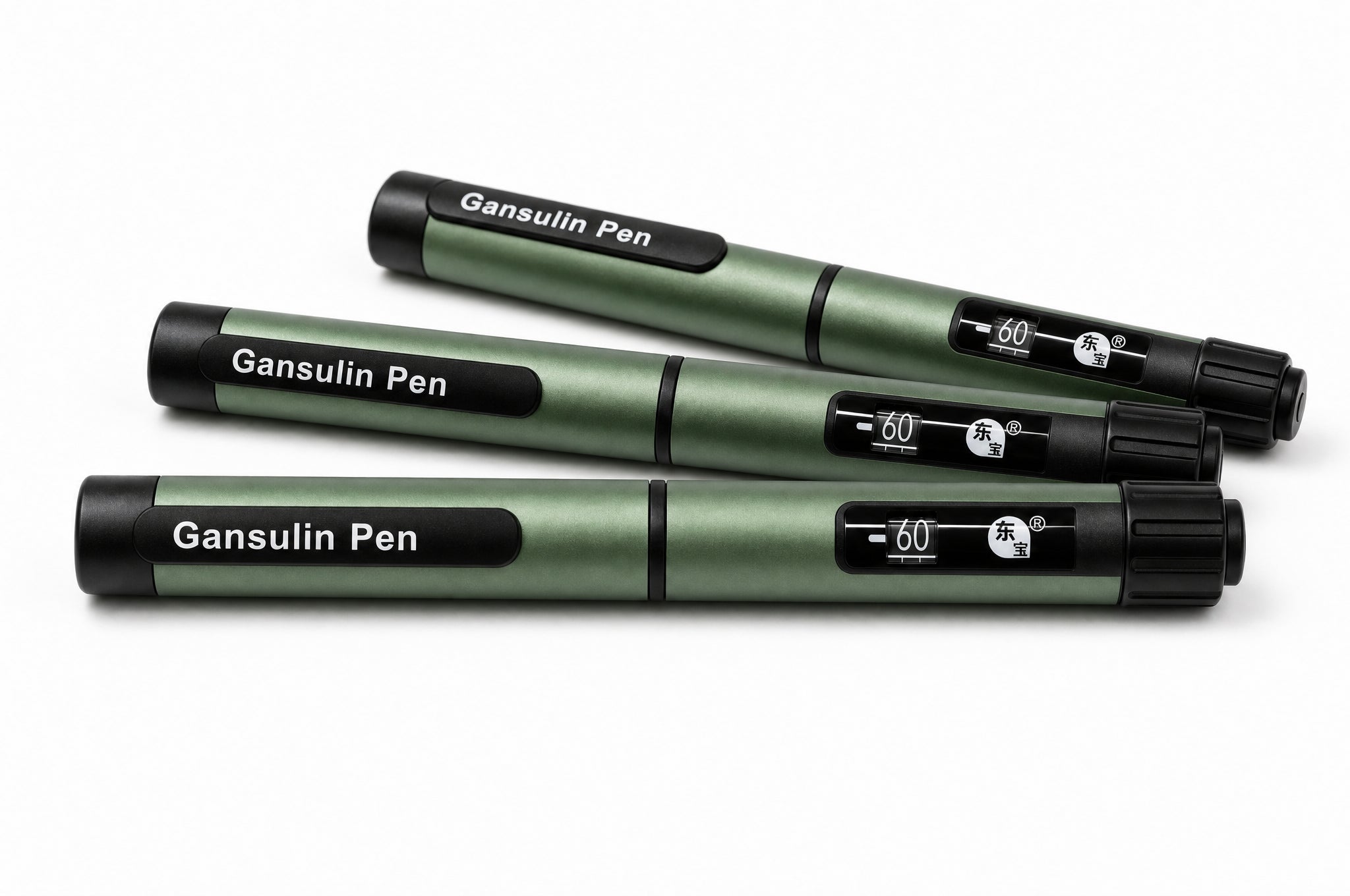 Three capped Gansulin pens laid out diagonally on a pale studio background