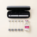 Starter kit laid out: a silver pen in its open grey case, five empty glass cartridges and a 30 mL vial of bacteriostatic water