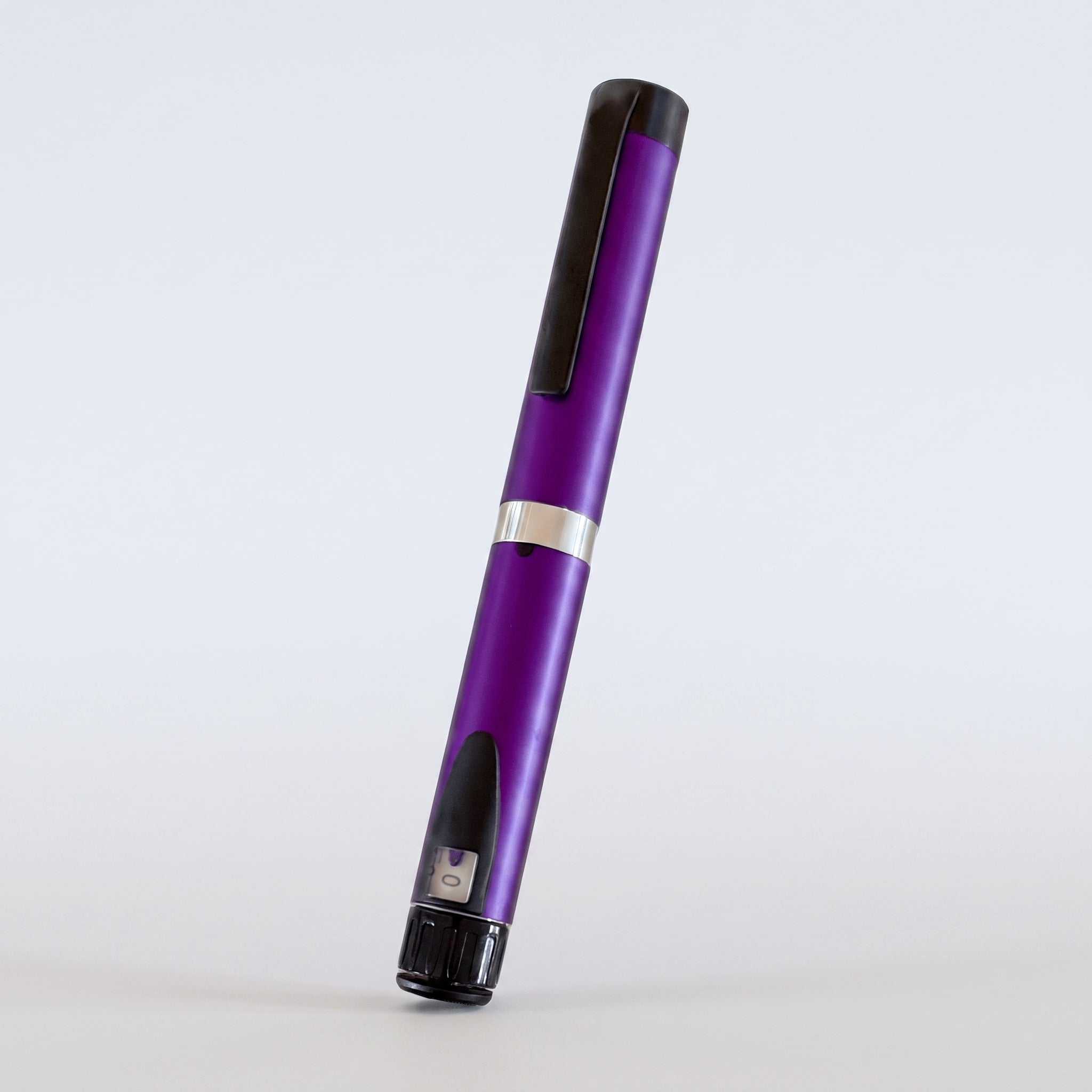 Purple V3 Peptide Pen, reusable aluminium click-dial pen, angled diagonally on a pale studio background