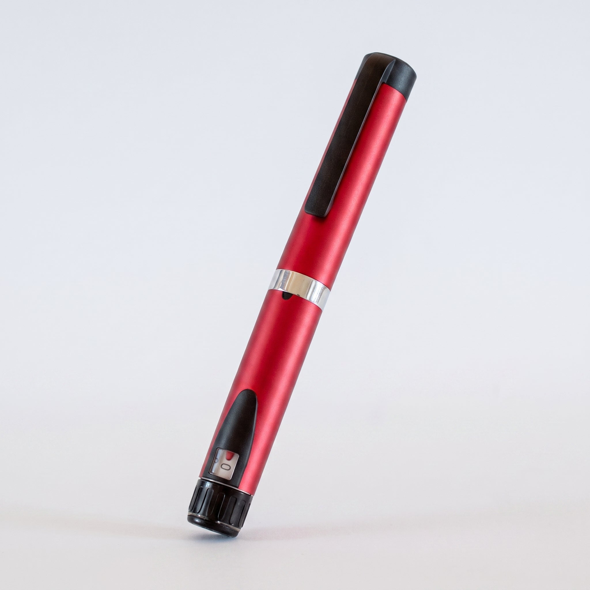 Red V3 Peptide Pen, reusable aluminium click-dial pen, angled diagonally on a pale studio background