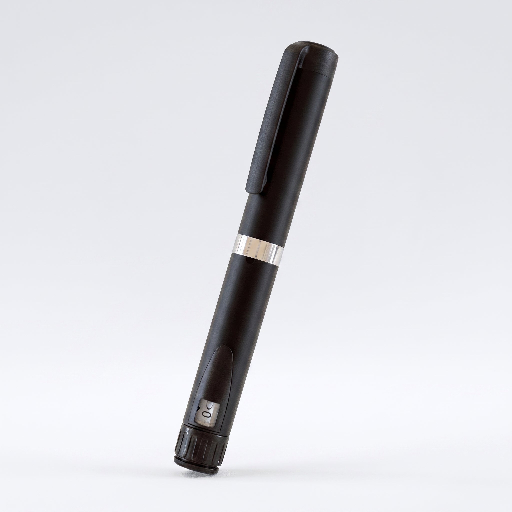 Matte black V3 Peptide Pen, reusable aluminium click-dial pen, angled diagonally on a pale studio background