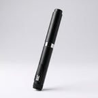 Matte black V2 Peptide Pen, reusable 60-unit pen with needle shield, angled diagonally on a pale studio background