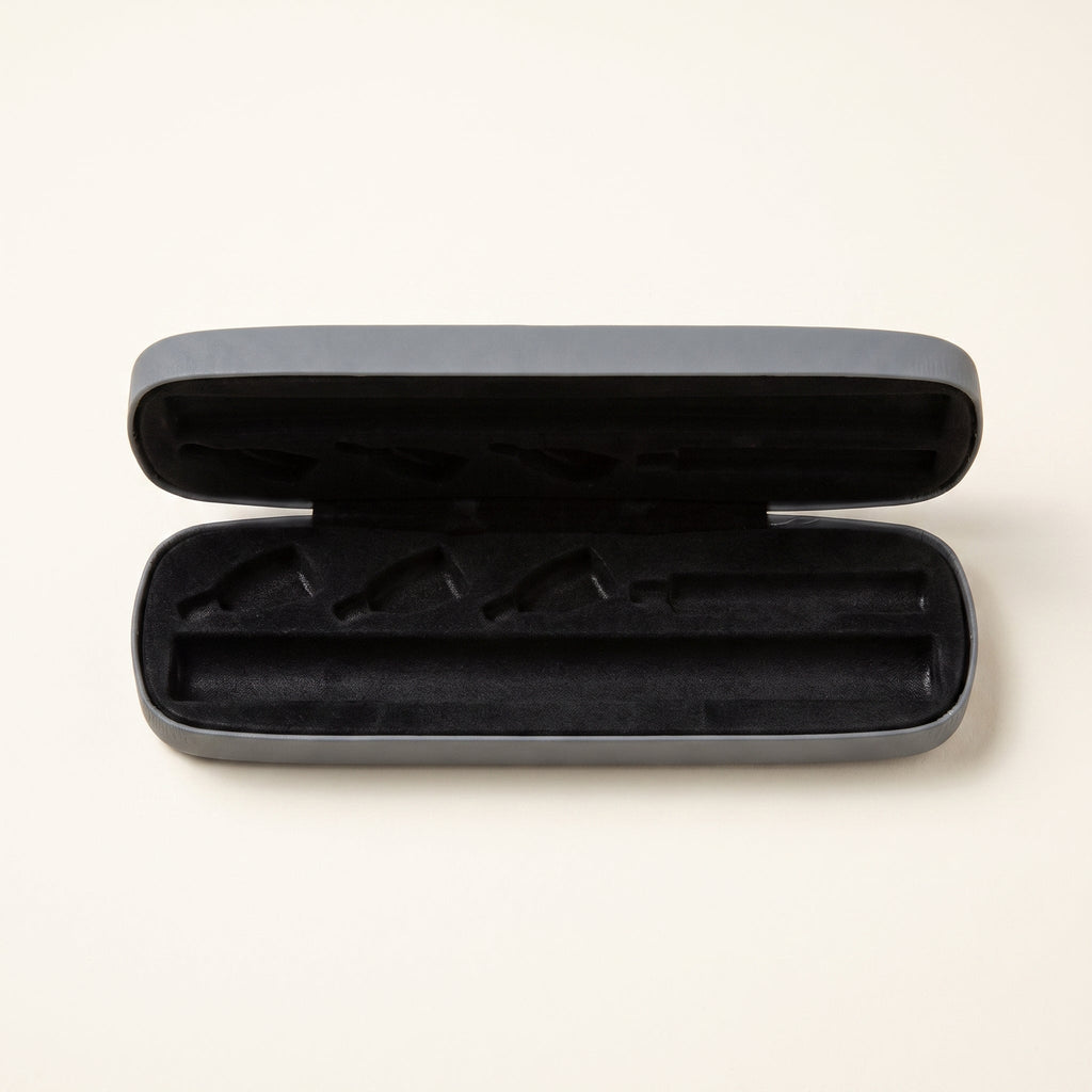 Open grey hard carry case, empty, showing the black moulded foam with slots for a pen and cartridges
