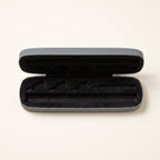 Open grey hard carry case, empty, showing the black moulded foam with slots for a pen and cartridges