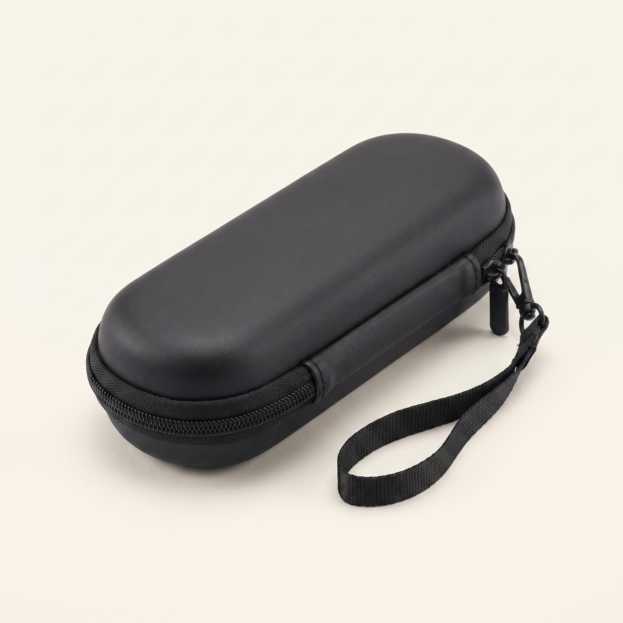 Closed black EVA travel case with a zip around the edge and a woven wrist strap