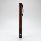 Dark brown V1 Peptide Pen, reusable manual click-dial pen, standing upright on a pale studio background