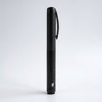 Matte black V1 Peptide Pen, reusable manual click-dial pen, standing upright on a pale studio background