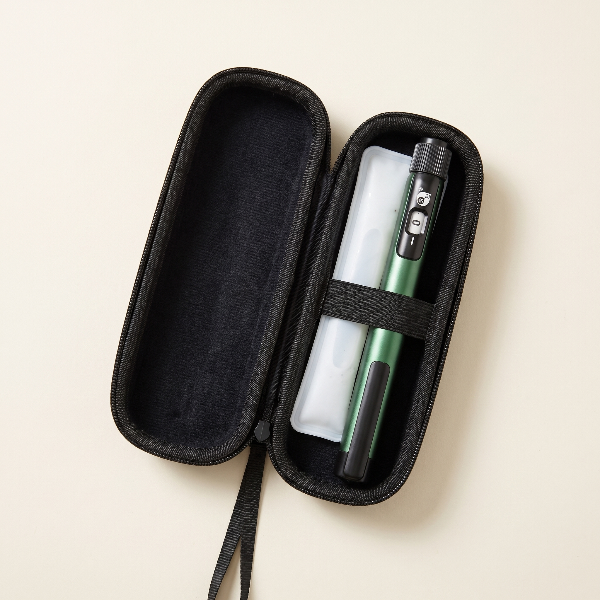EVA travel case open with pen held by the elastic strap and a gel ice pack