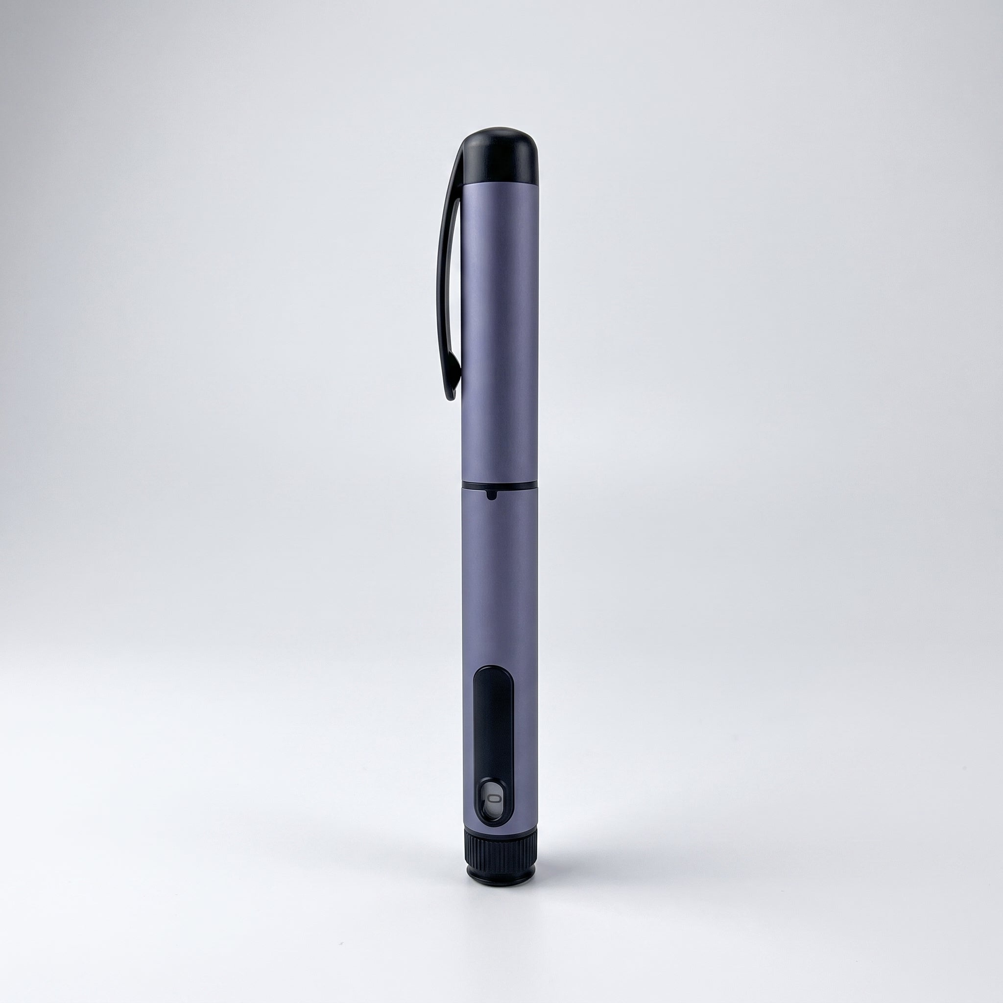 Slate grey V1 Peptide Pen, reusable manual click-dial pen, standing upright on a pale studio background