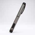 Gunmetal grey V1 Peptide Pen, reusable manual click-dial pen, angled diagonally on a pale studio background