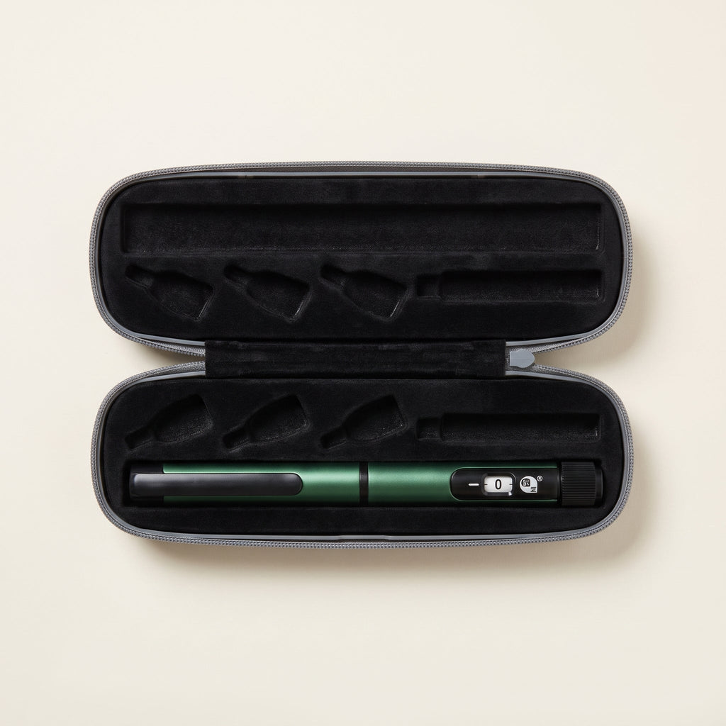 Open grey hard carry case with a green reconstitution pen held under its elastic strap